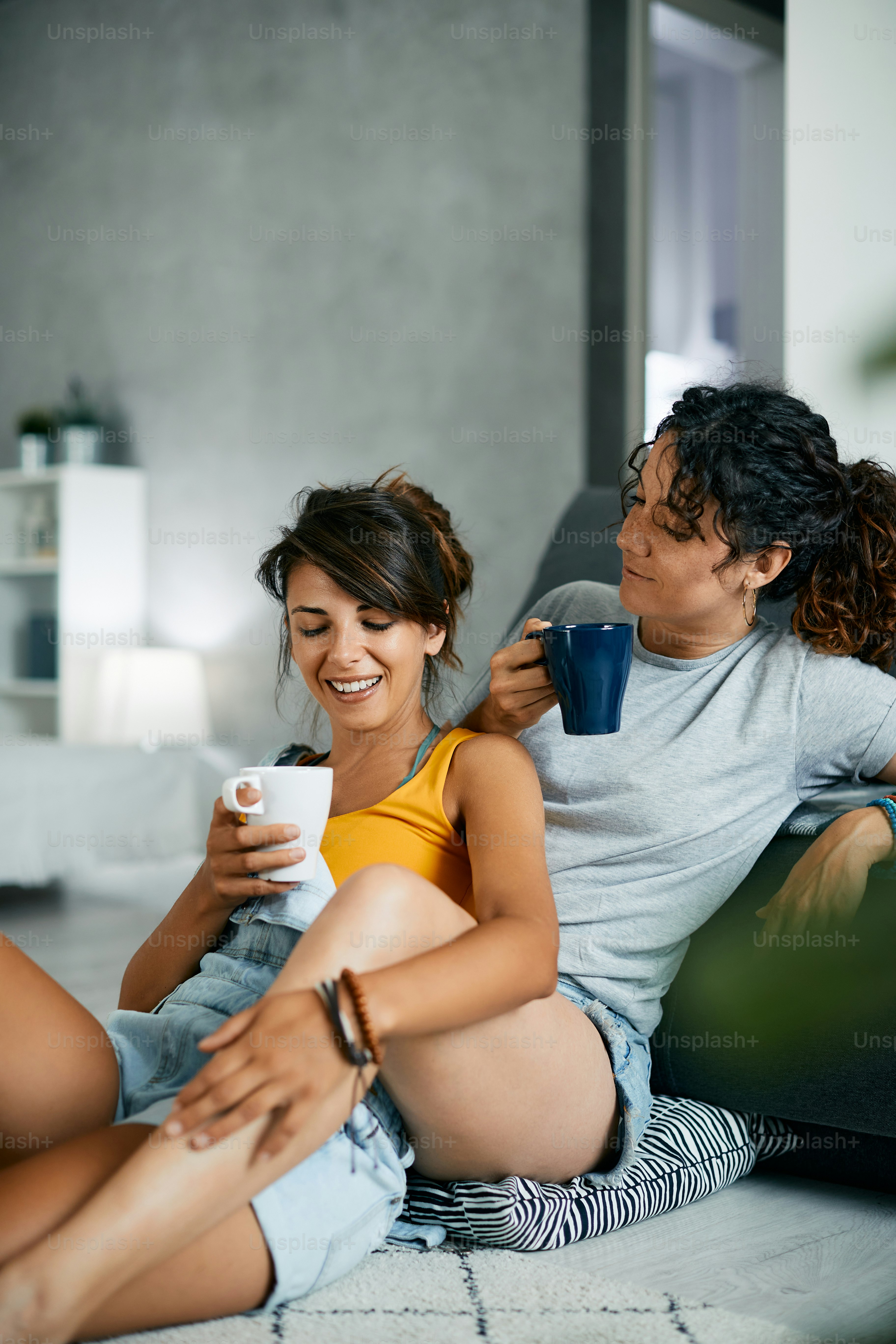 Jovem casal feminino apaixonado desfrutando em sua hora do café e relaxando em casa.