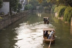 a couple of small boats traveling down a river