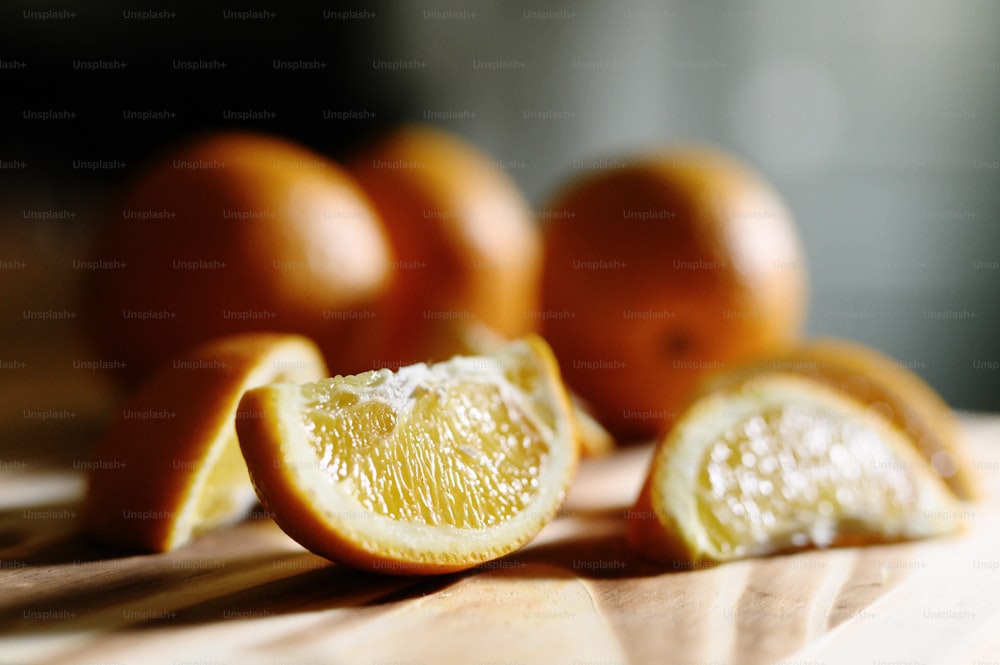 Uma tábua de corte com laranjas fatiadas e inteiras
