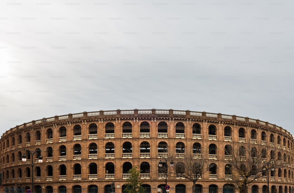 흐린 하늘을 배경으로 한 발렌시아 시내의 투우 경기장은 1850 년에서 1859 년 사이에 지어진 신고전주의 스타일의 플라자 드 토로스 (Plaza de Toros)입니다.