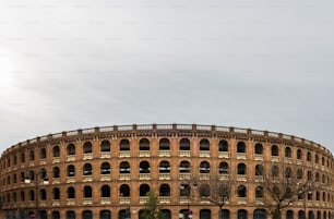 흐린 하늘을 배경으로 한 발렌��시아 시내의 투우 경기장은 1850 년에서 1859 년 사이에 지어진 신고전주의 스타일의 플라자 드 토로스 (Plaza de Toros)입니다.