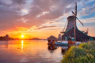 Cena rural da Holanda - - moinhos de vento no famoso local turístico Zaanse Schans, na Holanda, ao pôr do sol com céu dramático. Zaandam, Países Baixos