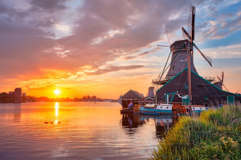 Escena rural de los Países Bajos - - molinos de viento en el famoso sitio turístico Zaanse Schans en Holanda en la puesta del sol con el cielo dramático. Zaandam, Países Bajos