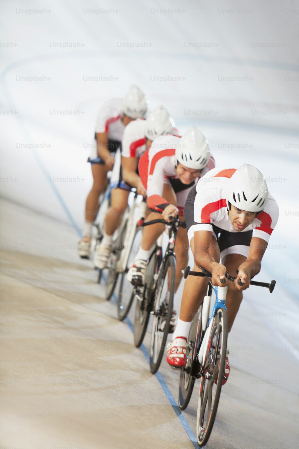a group of men riding bikes down a track