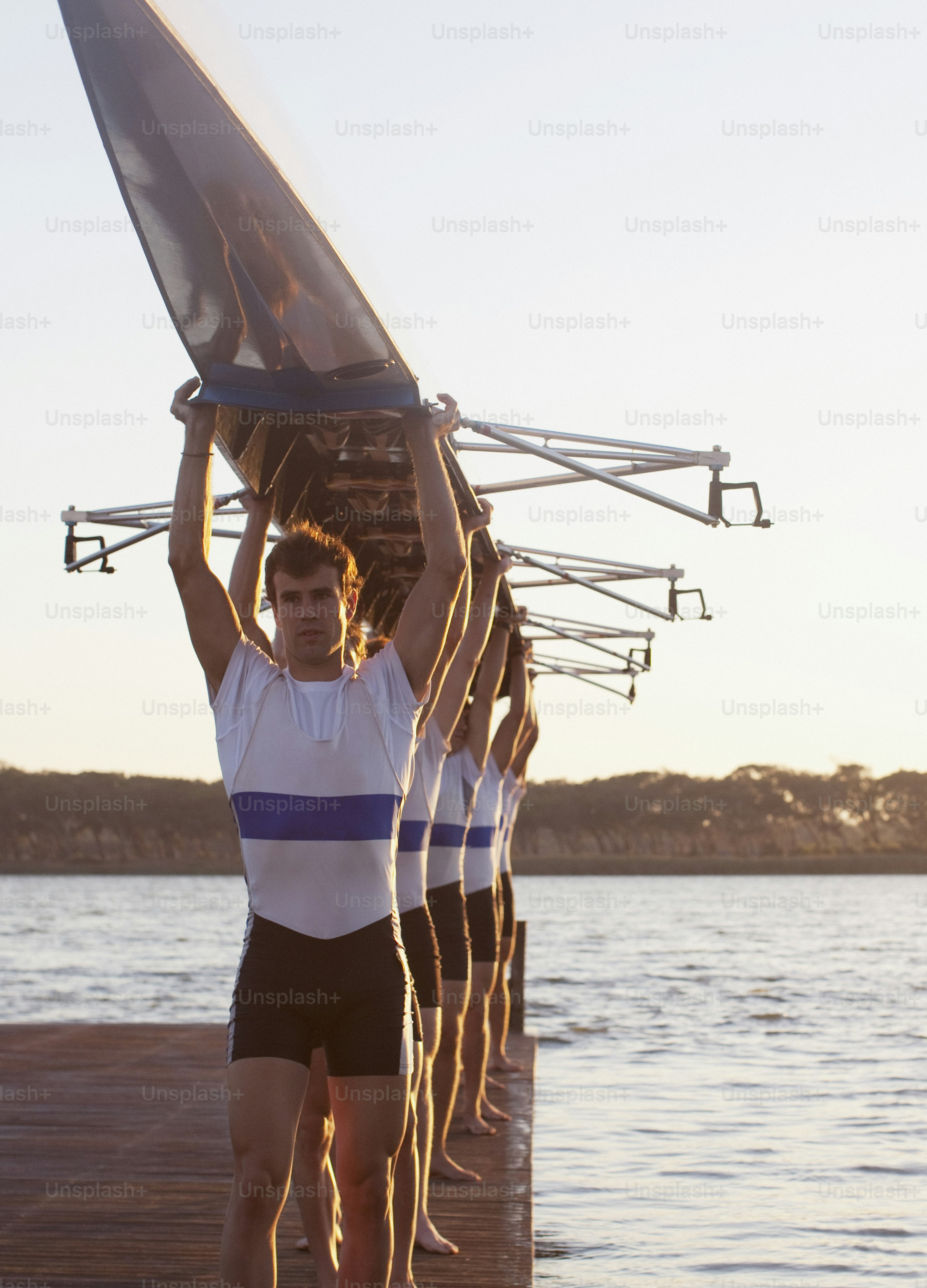 Un hombre sosteniendo una vela en la parte superior de un barco