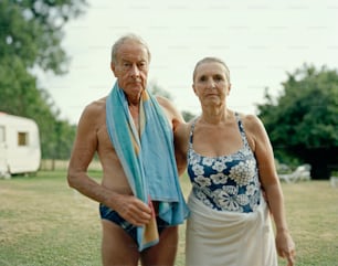 a man and a woman standing next to each other in a field