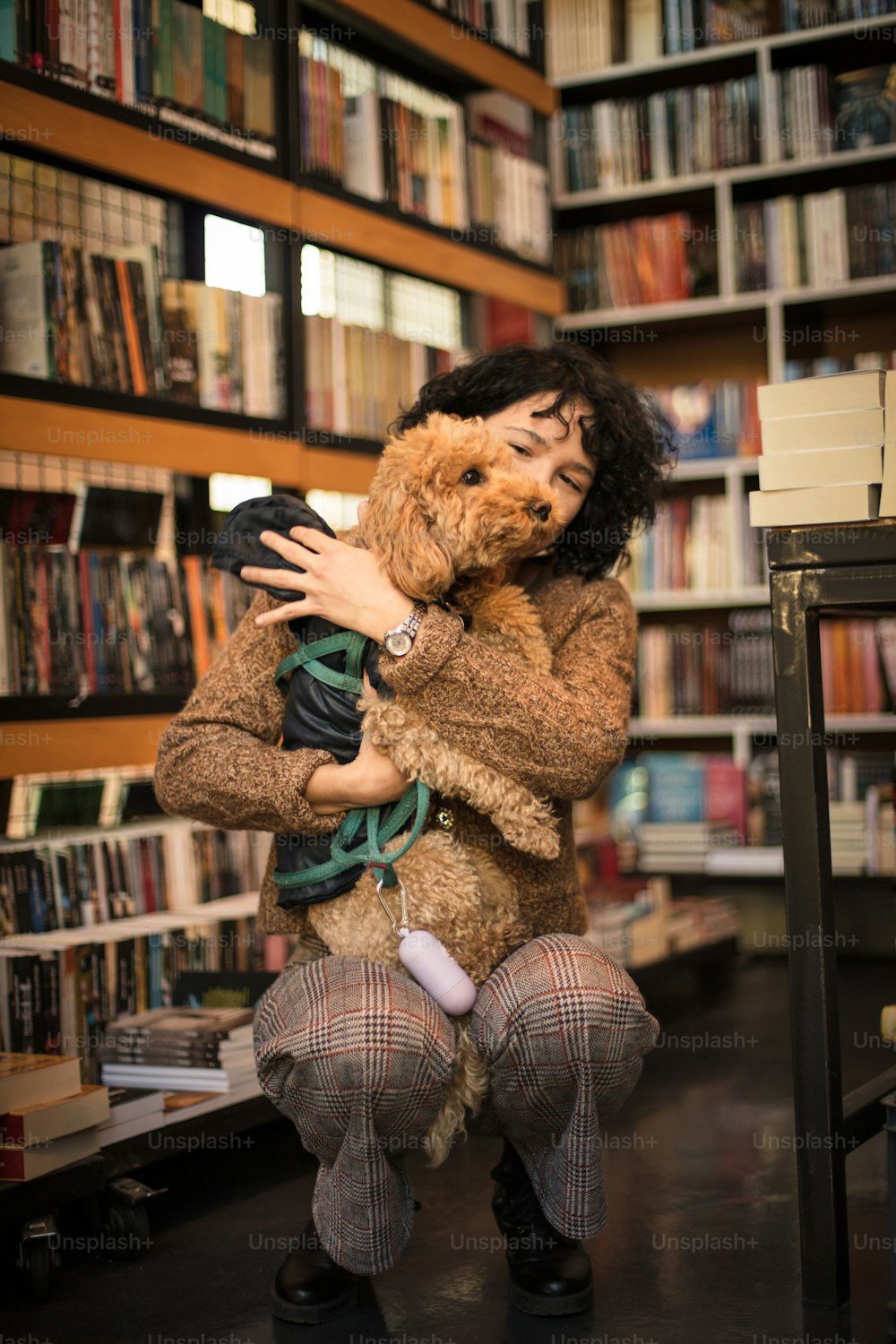Mujer feliz con su perro en la biblioteca.