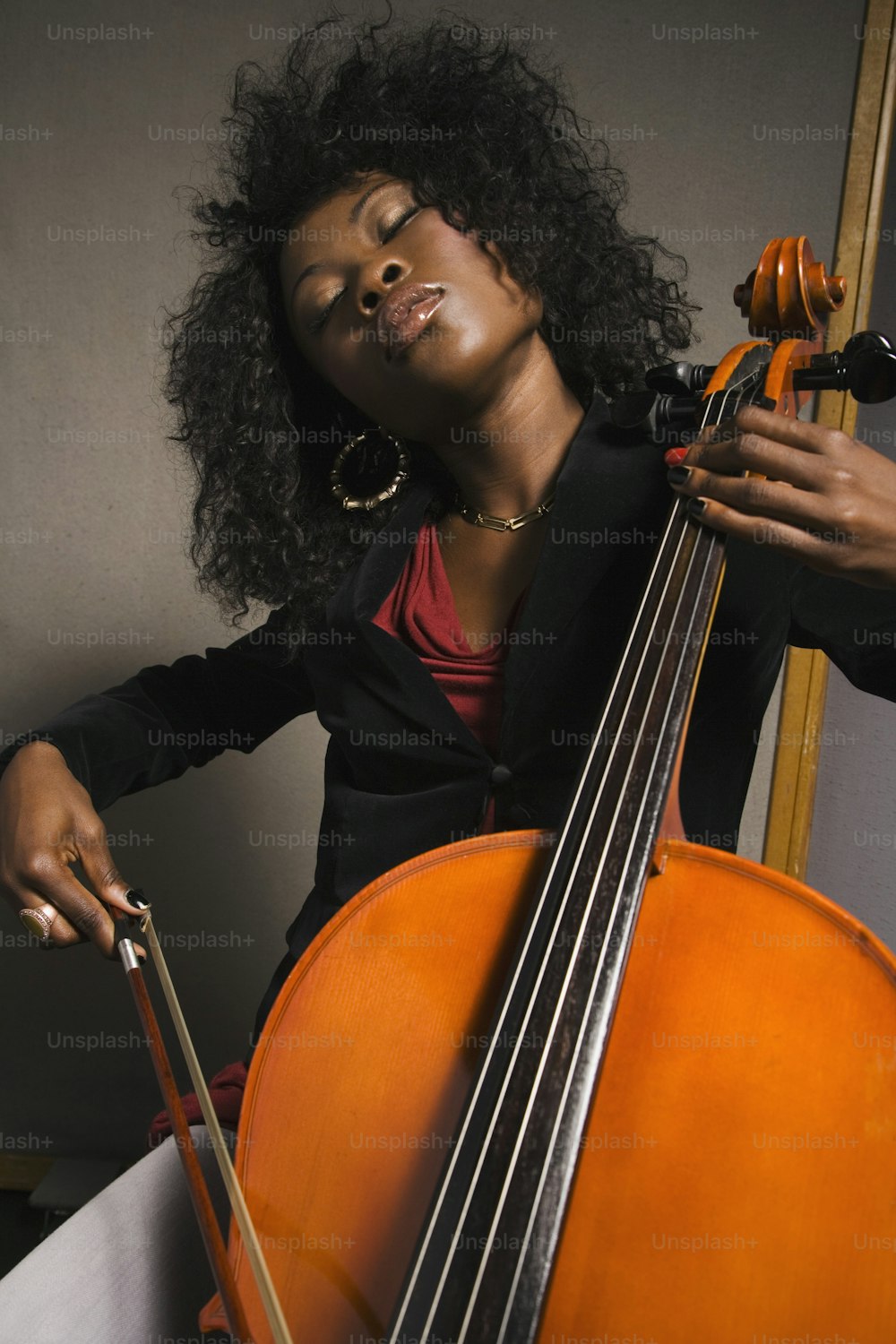 uma mulher segurando um violoncelo na mão direita