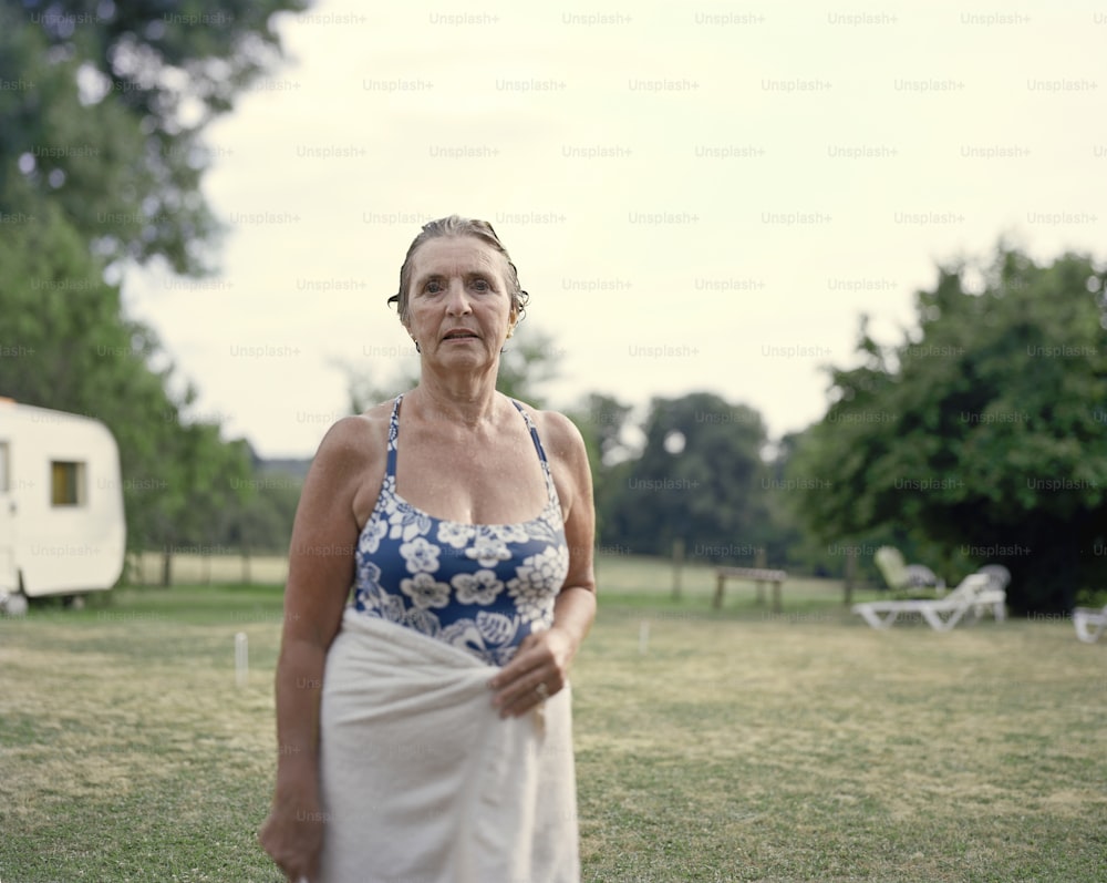 a woman in a blue and white dress standing in a field