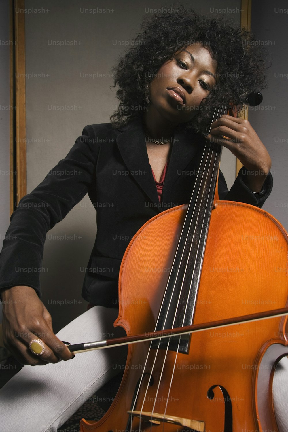 a woman in a suit holding a cello