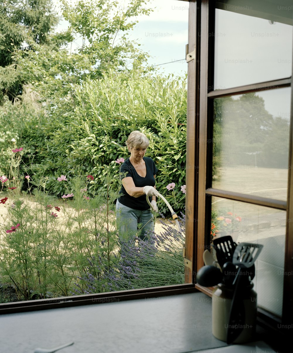 a woman in a black shirt is cleaning a window