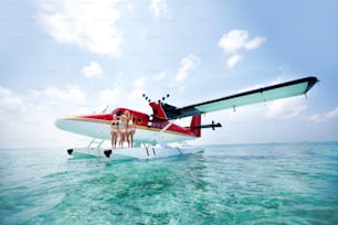 a group of people standing on the front of a plane in the ocean