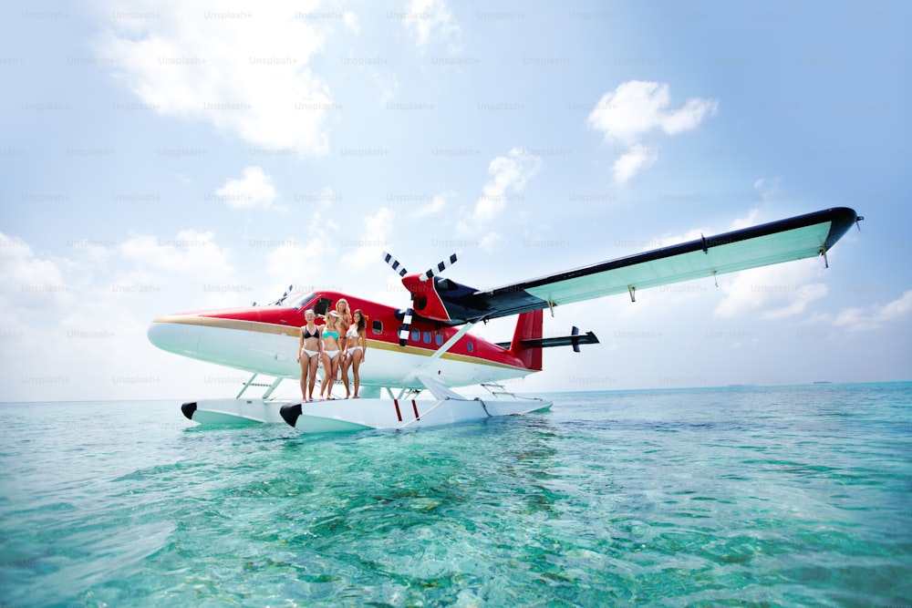 a group of people standing on the front of a plane in the ocean