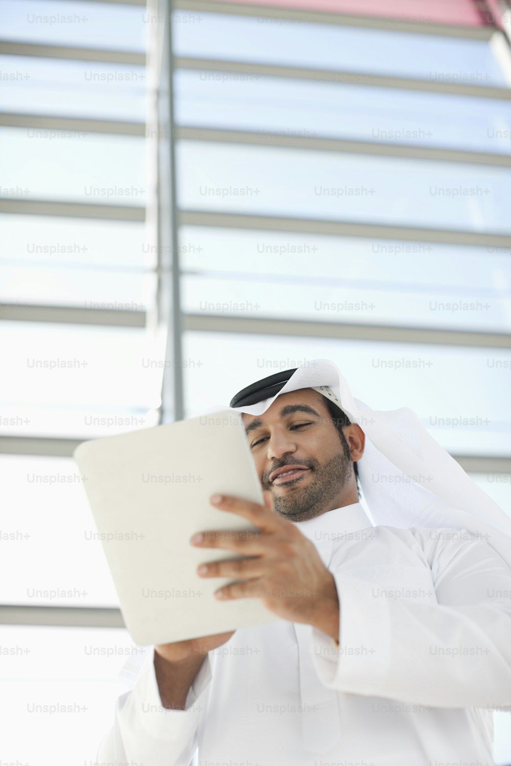 a man in a white suit holding a laptop