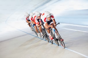 a group of people riding bikes on a track