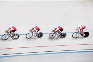 a group of men riding bikes down a track