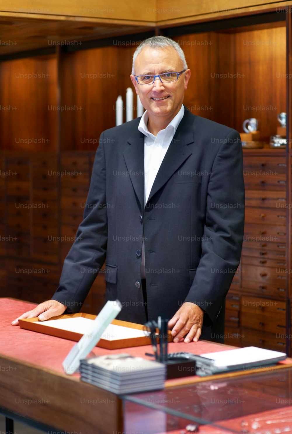 Un uomo in giacca e cravatta in piedi a una scrivania