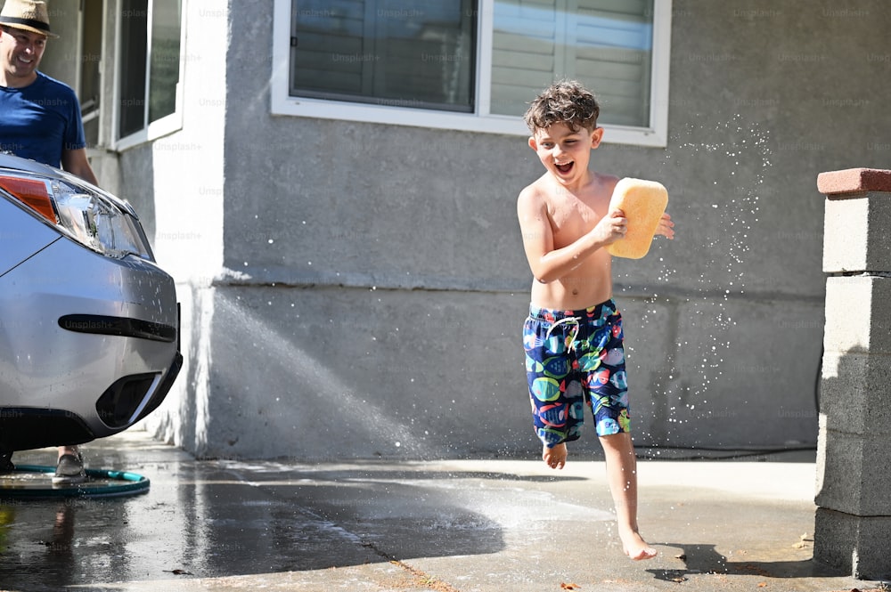 Ein kleiner Junge, der in einer Prise Wasser spielt