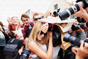 a woman is surrounded by photographers and photographers