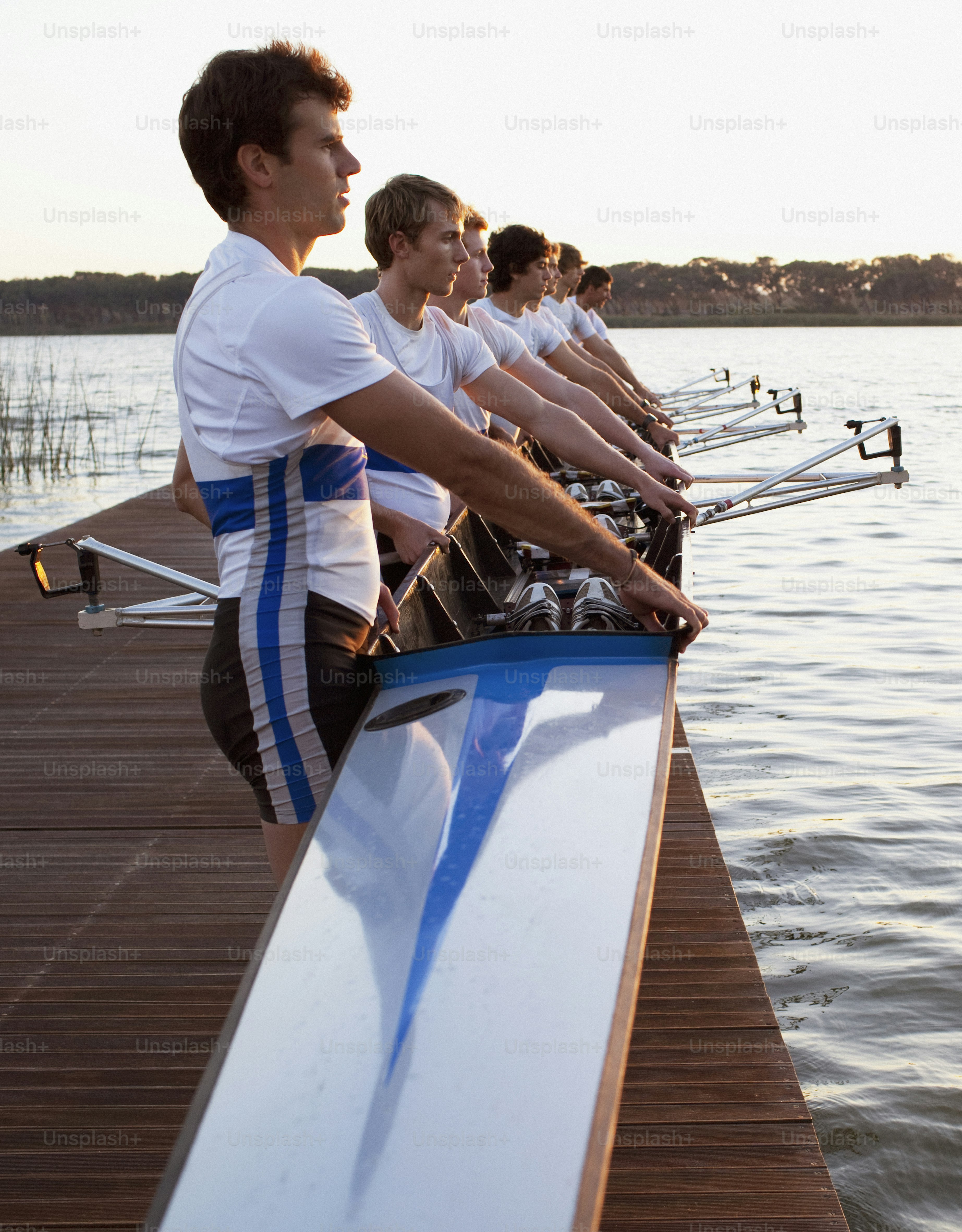 a group of men standing on top of a wooden pier