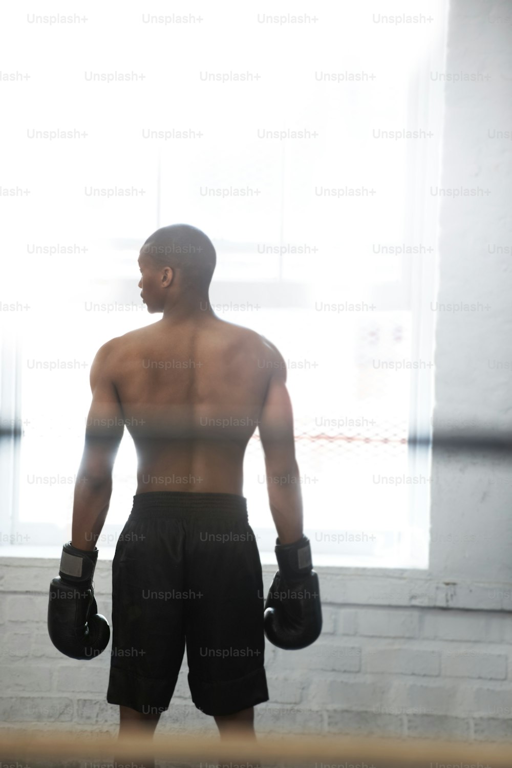 Un hombre parado en un ring de boxeo con guantes de boxeo