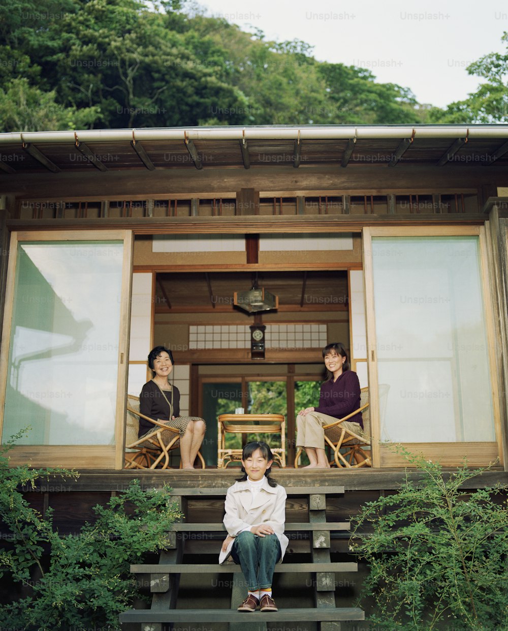 Grandmother, mother and daughter (9-11) sitting on porch, portrait