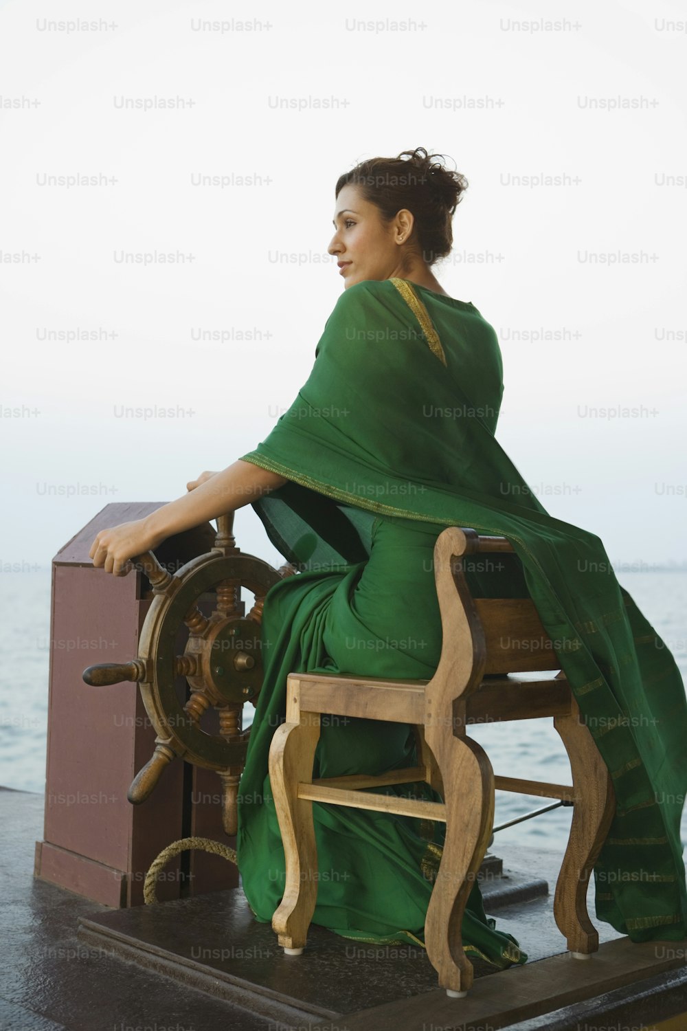 a woman in a green sari sitting on a boat