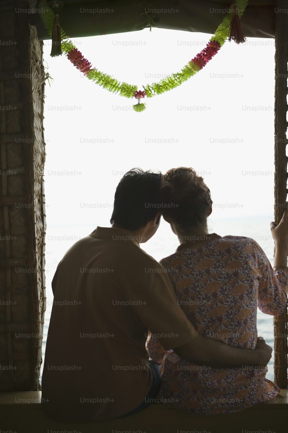 a man and a woman sitting on a window sill