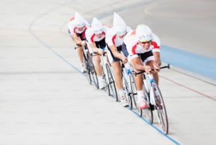 a group of men riding bikes down a track