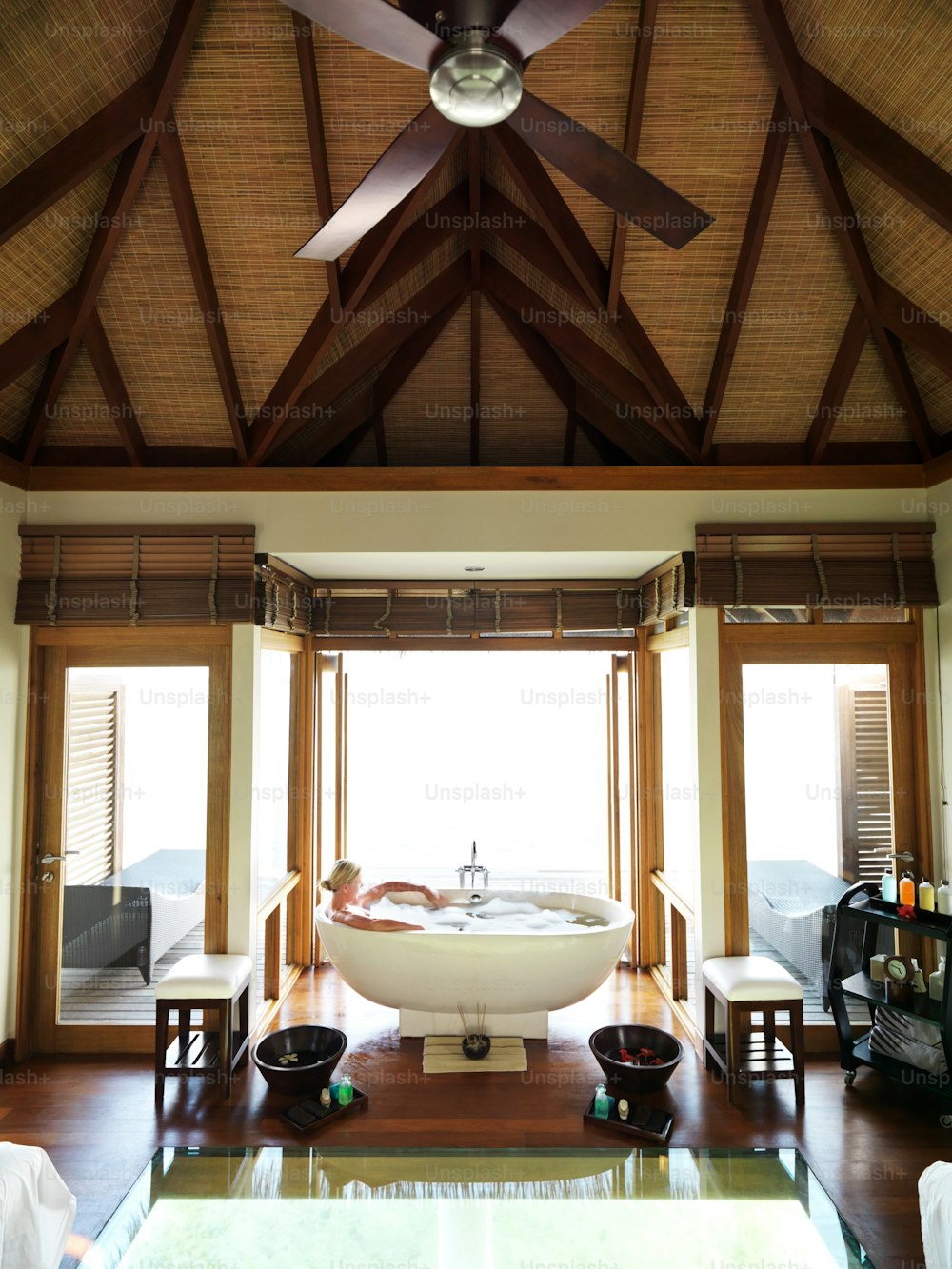 a bathroom with a large bathtub and a ceiling fan