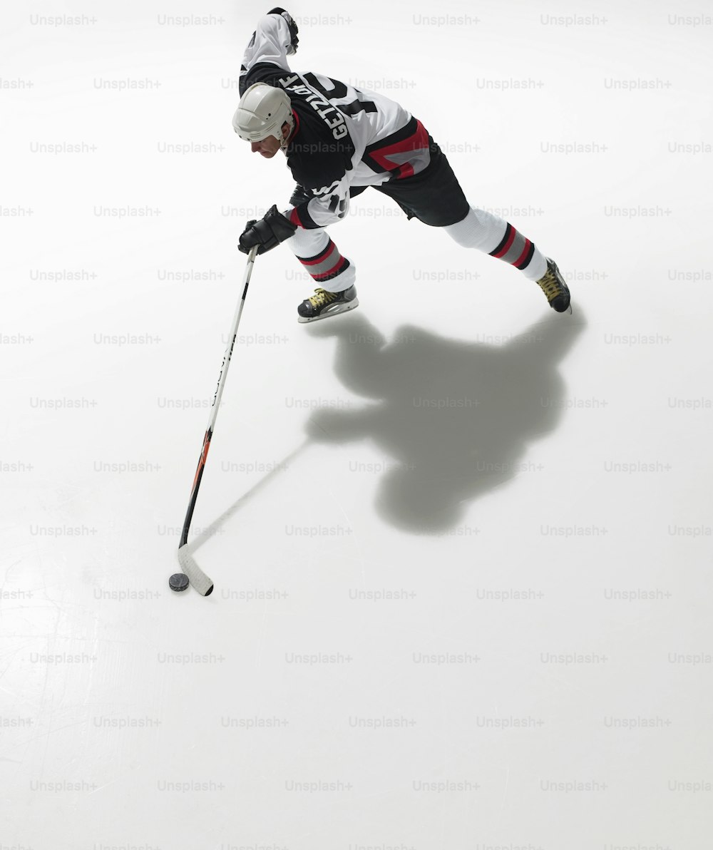 Un homme en uniforme noir et blanc joue au hockey