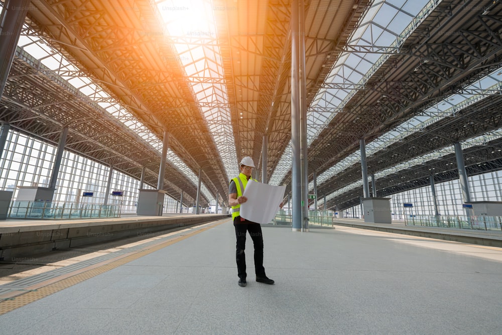엔지니어 철도 검사 및 건설 과정 철도 확인 및 기차역 작업 확인. 안전 유니폼과 안전 헬멧을 착용 한 엔지니어.