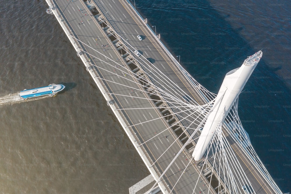 河口に架かる斜張橋、橋梁の上からの空撮。ボートが水に浮かぶ