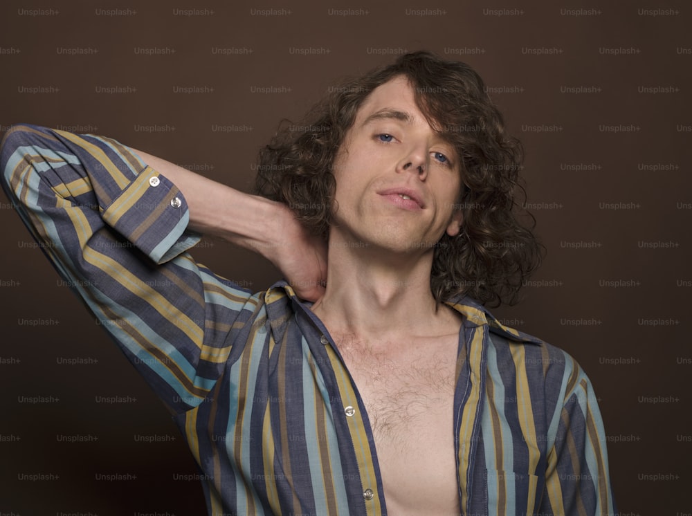 a man with long curly hair wearing a striped shirt