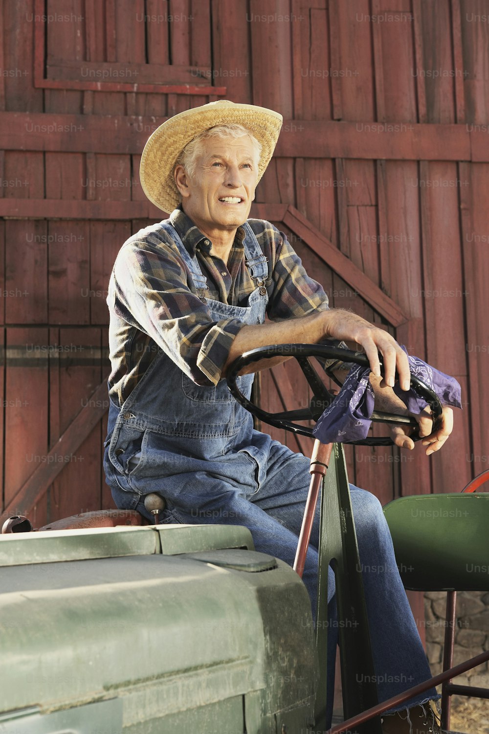 Un homme coiffé d’un chapeau de paille assis sur un tracteur