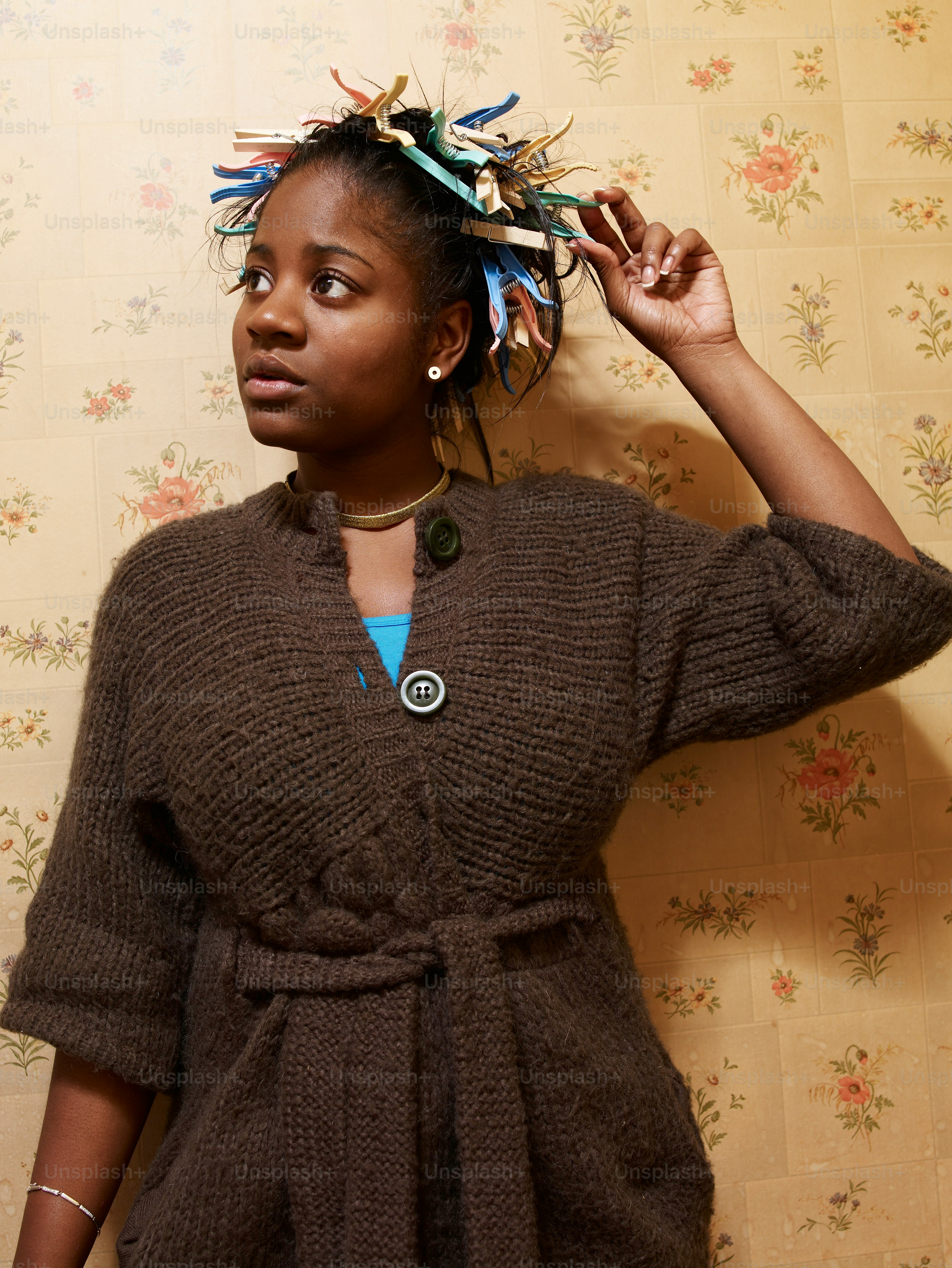 a woman wearing a brown sweater and a blue necklace