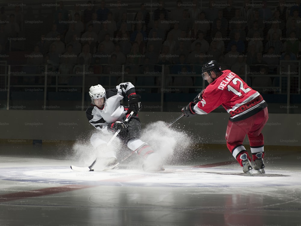a couple of men playing a game of ice hockey