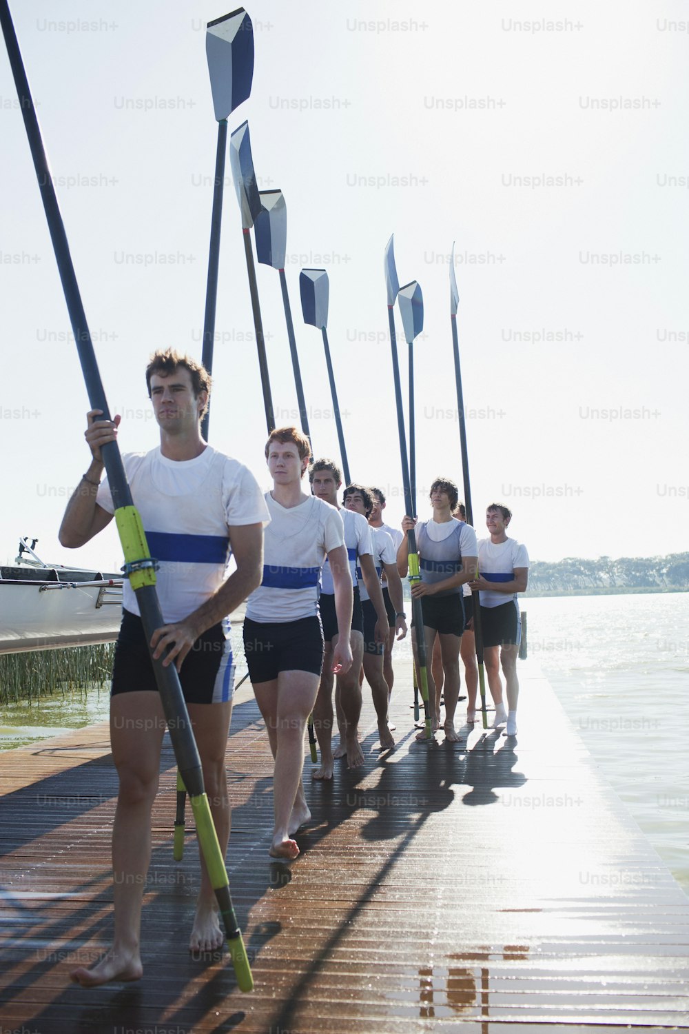 a group of people standing on a pier holding paddles