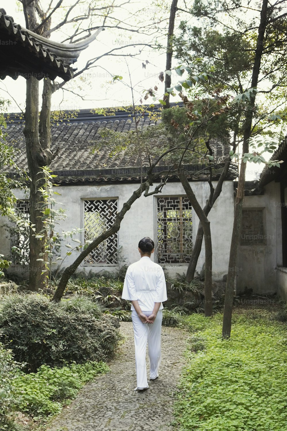 a man walking down a path in front of a building