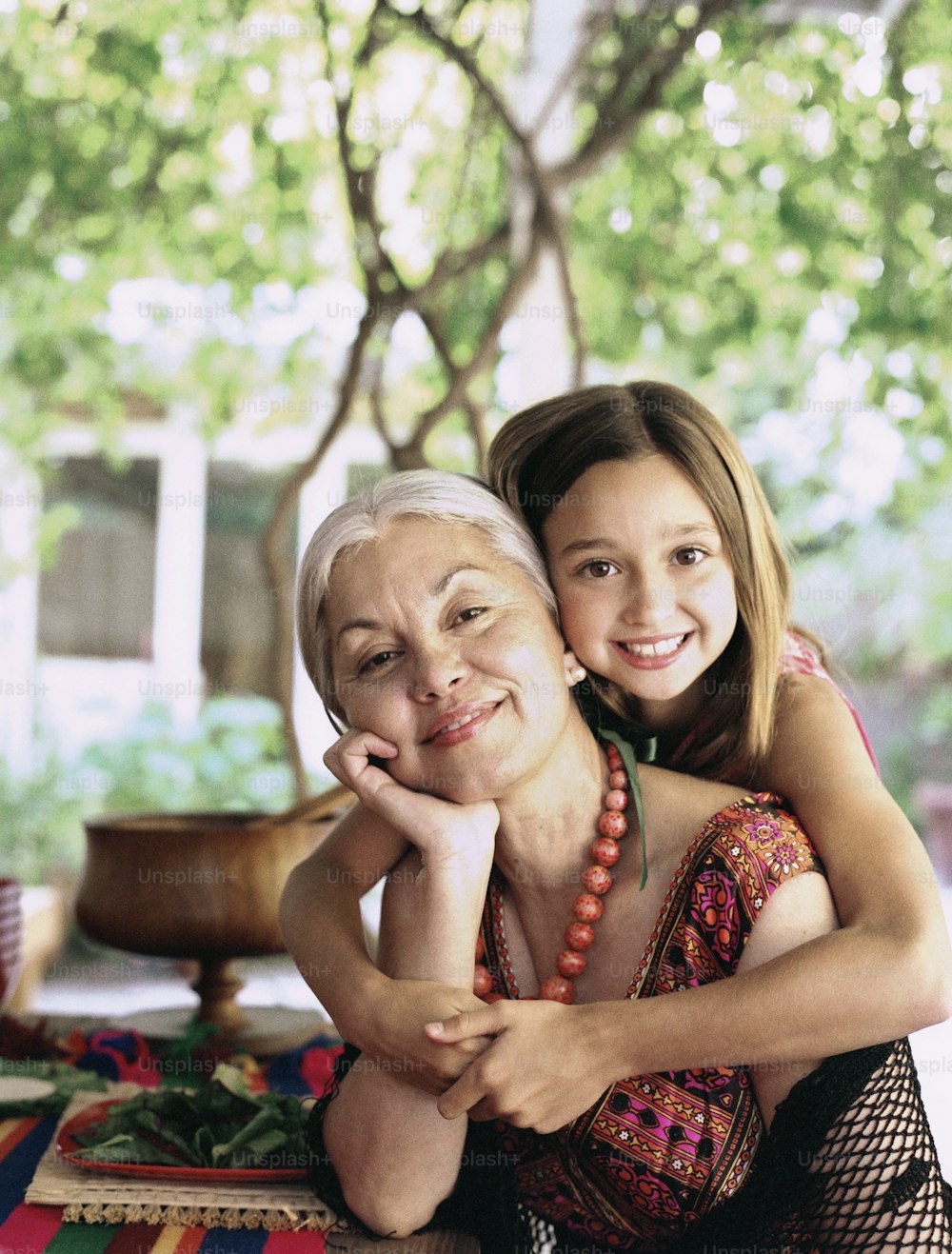 an older woman and a young girl sitting on a rug