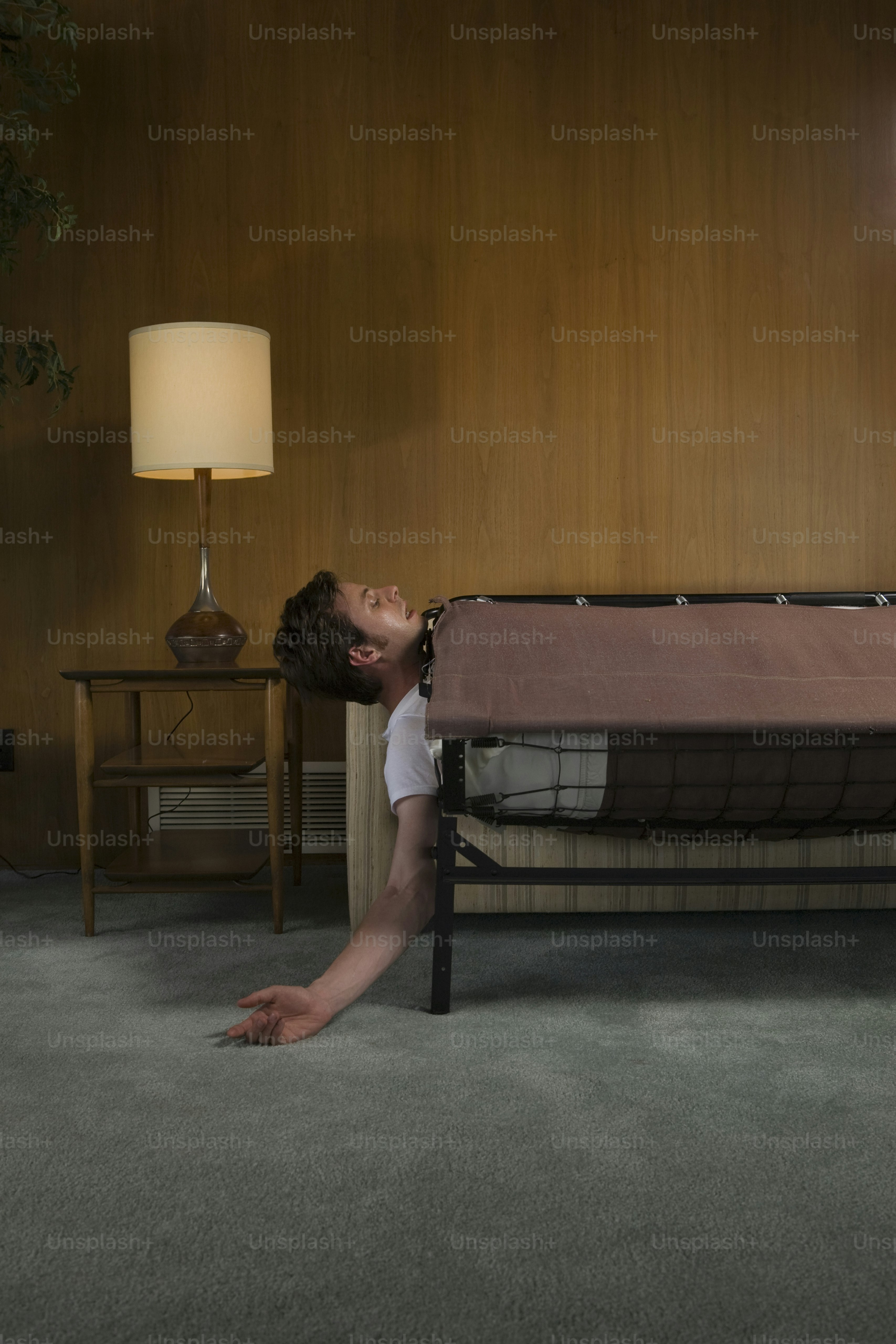 a person laying on the ground in front of a bed