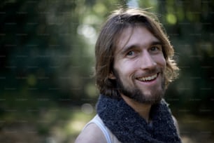 a man with long hair and a beard wearing a scarf