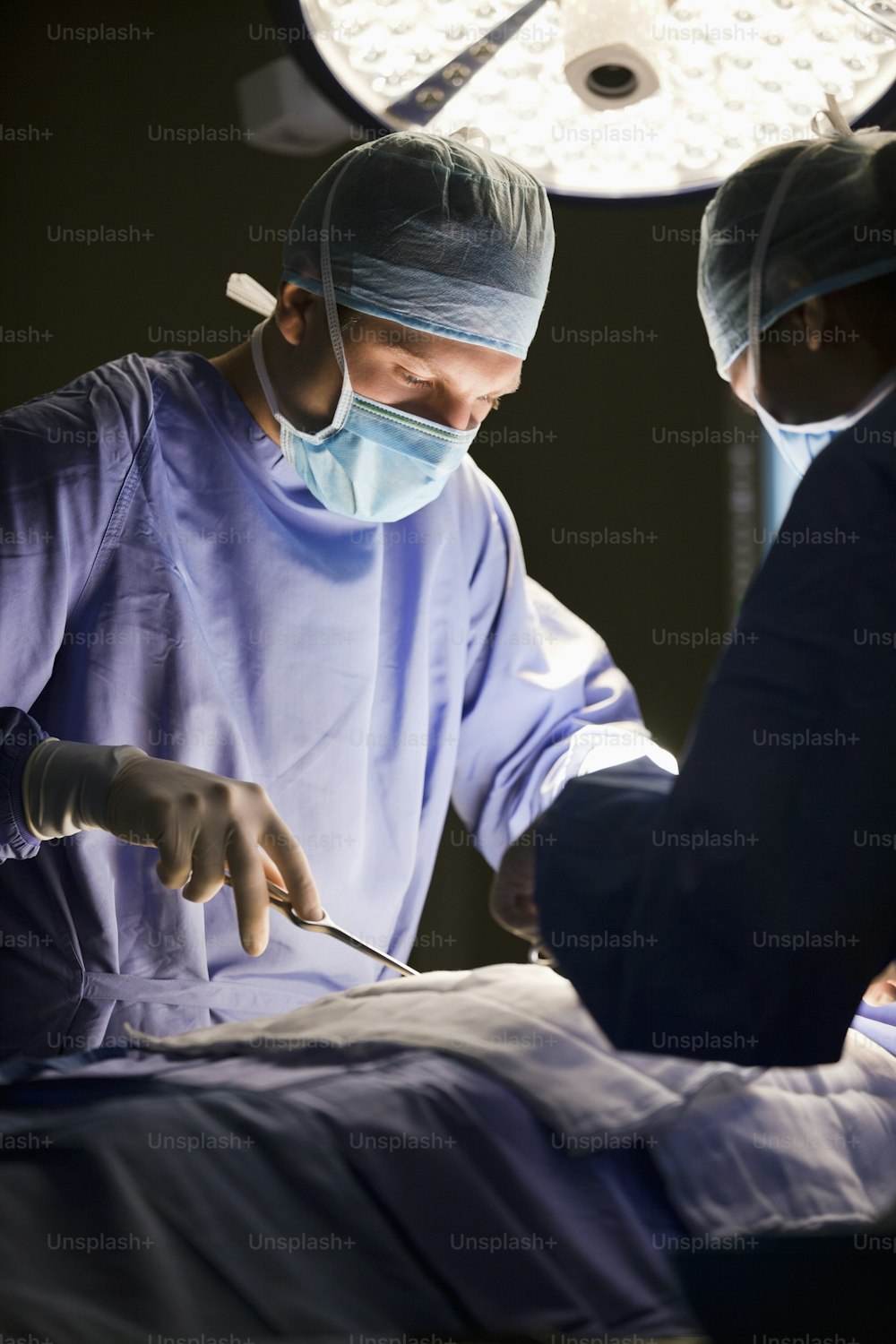 two surgeons performing surgery on a patient in a hospital