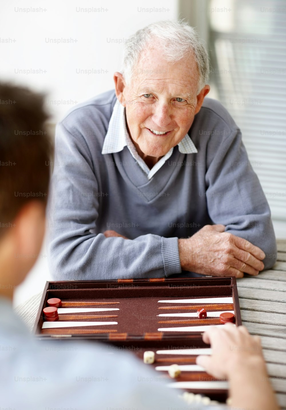 a man sitting at a table playing a game of checkers