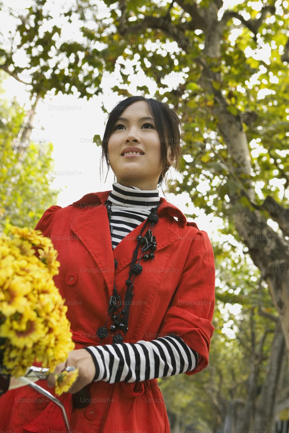 a woman in a red coat holding a basket of flowers