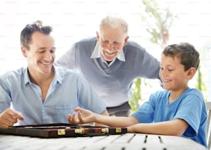 a man and two boys playing a board game