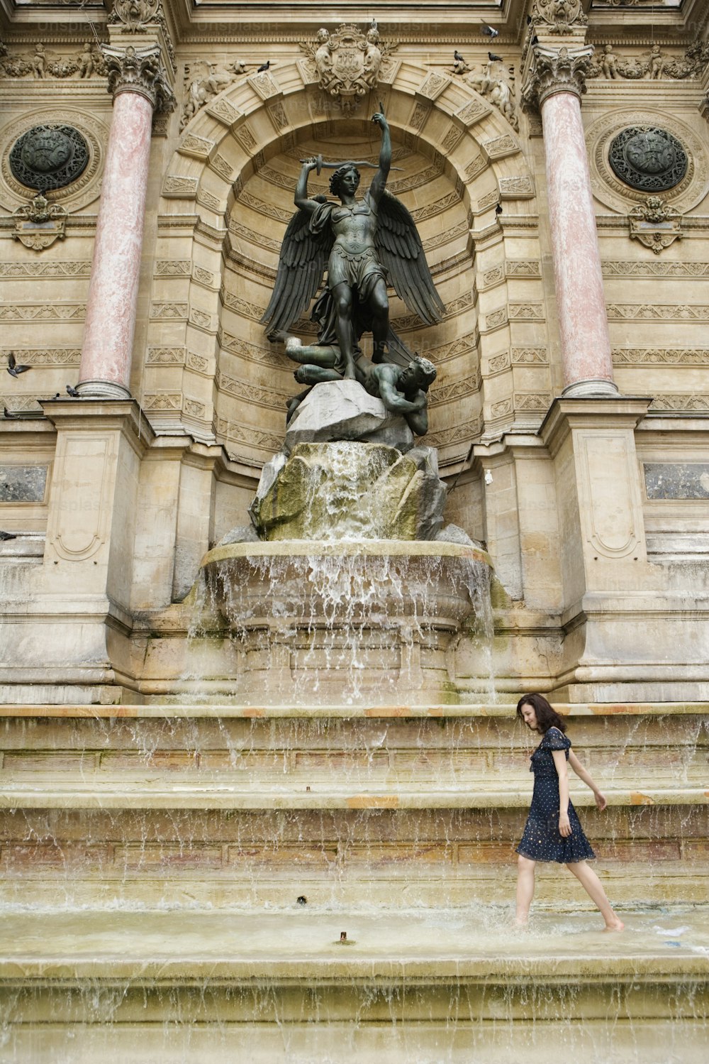 Eine Frau steht vor einem Brunnen