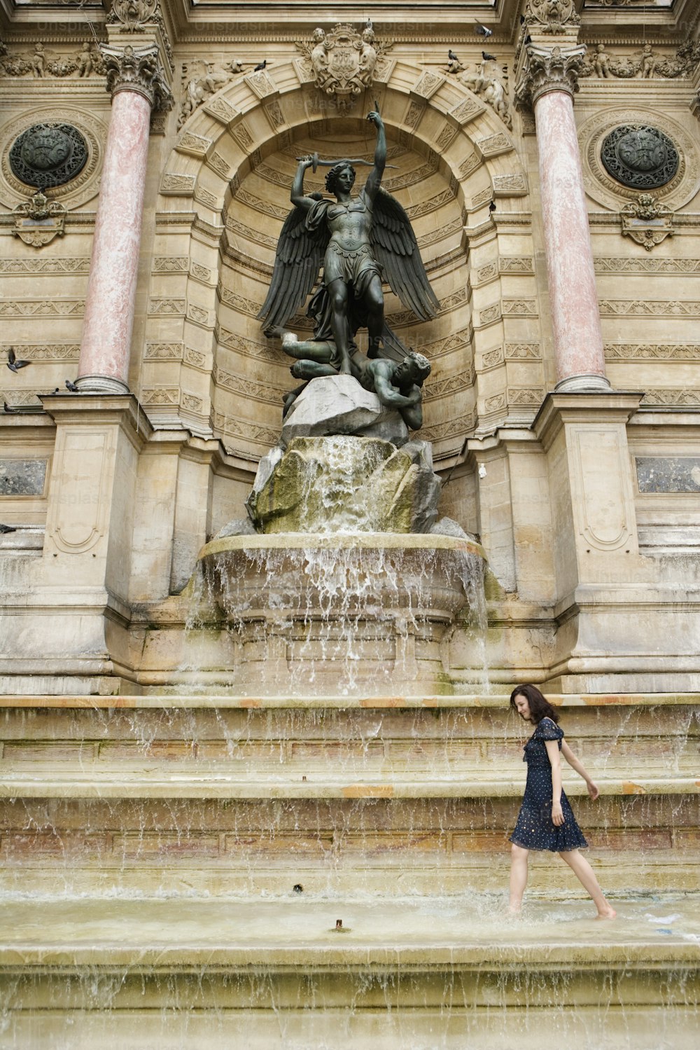 a woman is standing in front of a fountain
