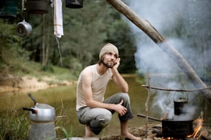 Un homme assis devant un feu de camp