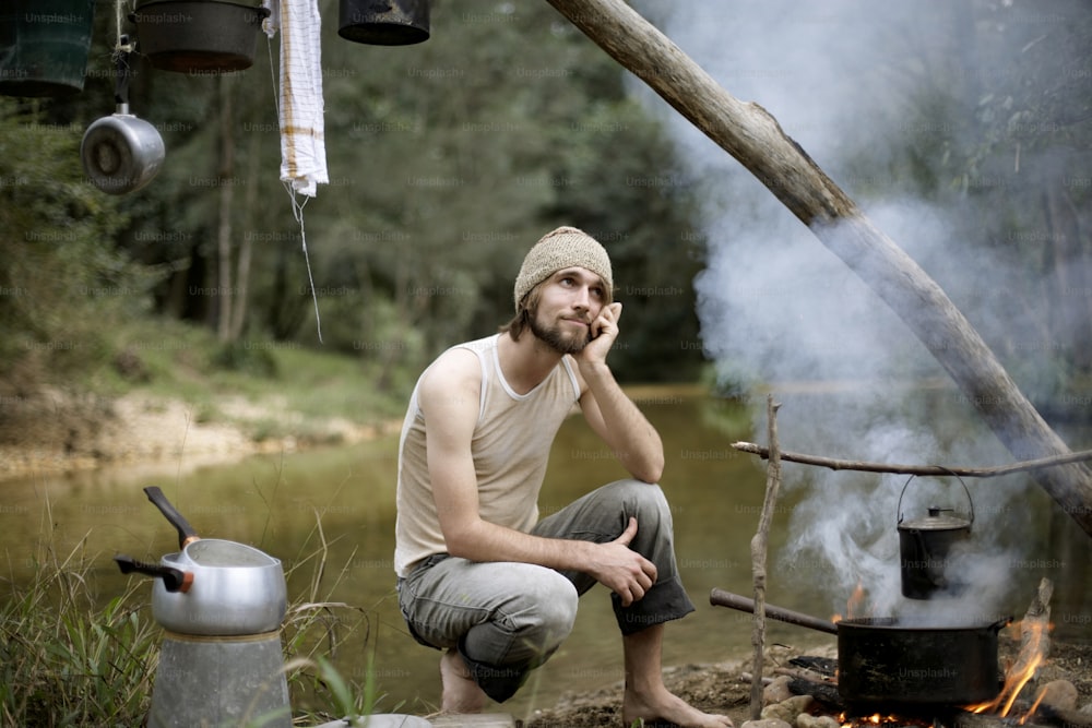 Un homme assis devant un feu de camp